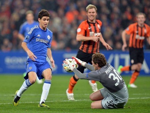 FC Shakhtar's goalkeeper Andriy Pyatov (R) catches the ball as Chelsea's Oscar (L) tries to score